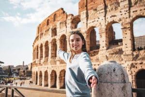 Jeune fille devant le Collisée de Rome nous invitant à le visiter